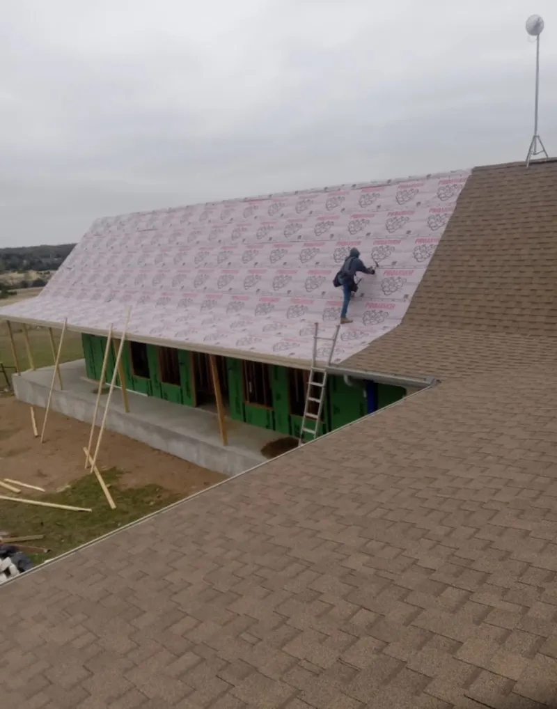 Worker preparing underlayment for a metal roof installation in Port Orange